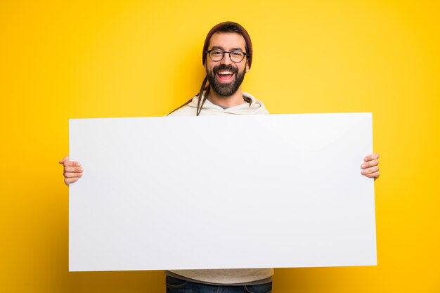 Hombre hippie con rastas sosteniendo un cartel para insertar un concepto