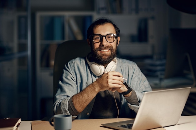 Hombre hipster feliz en la oficina de noche