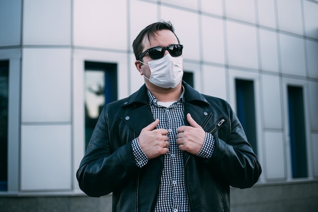 Hombre hipster con mascarilla médica en la calle