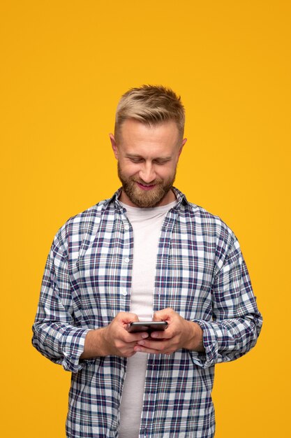 Hombre hipster positivo con smartphone