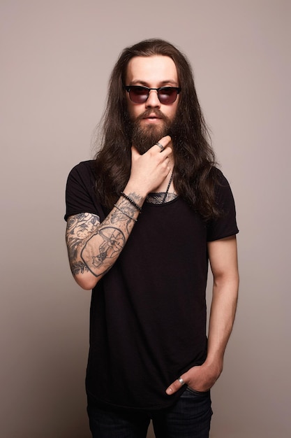 Hombre hipster con tatuaje y gafas de sol