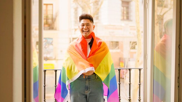 Hombre hispano con una bandera LGBT sonriendo