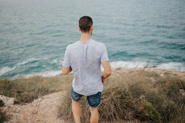 Un hombre hispano con barba cerca del mar en un parque de montaña en España