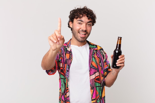 Hombre hispano con cerveza sintiéndose como un genio feliz y emocionado después de realizar una idea, levantando alegremente el dedo, ¡eureka!