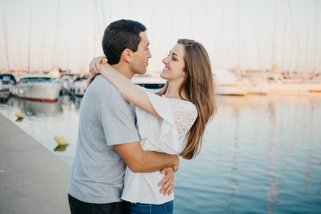 Un hombre hispano está abrazando a su novia morena feliz