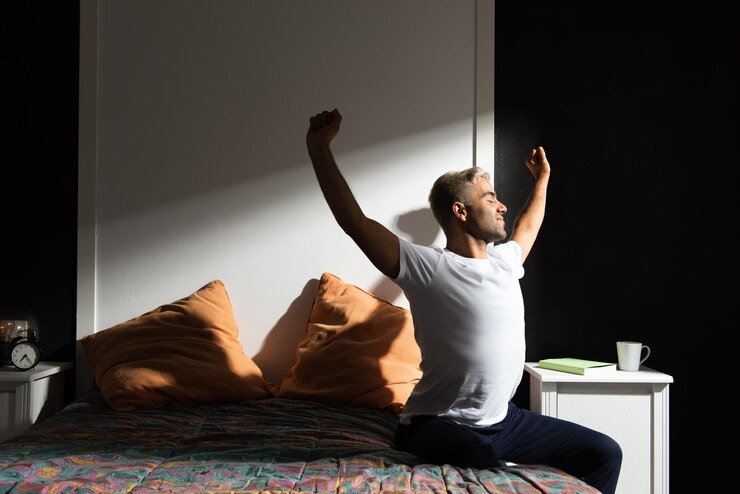 Hombre hispano estirándose en su dormitorio. Concepto de rutina matutina