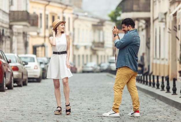 Hombre hispano fotografía a una mujer en la calle europea Concepto de viaje turístico