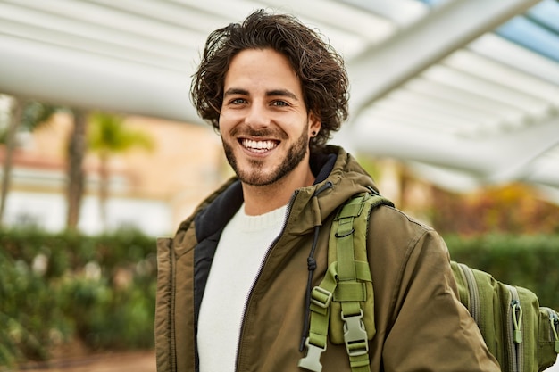 Hombre hispano guapo sonriendo a la ciudad