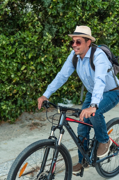 Hombre hispano monta bicicleta para trabajar en la ciudad