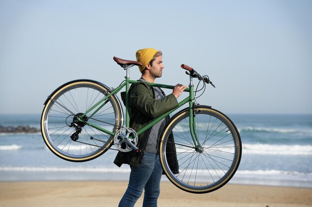 hombre hispano, proceso de llevar, clásico, bicicleta, en, hombros, en, el, costa