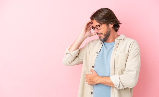 Hombre holandés senior aislado sobre fondo rosa con dolor de cabeza