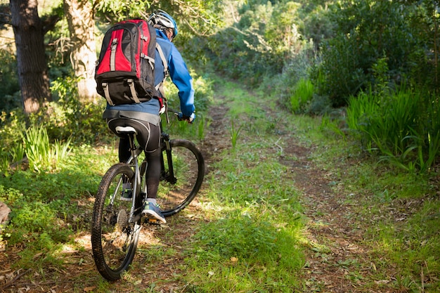 Hombre hombre ciclista de montaña montando bicicleta en el bosque