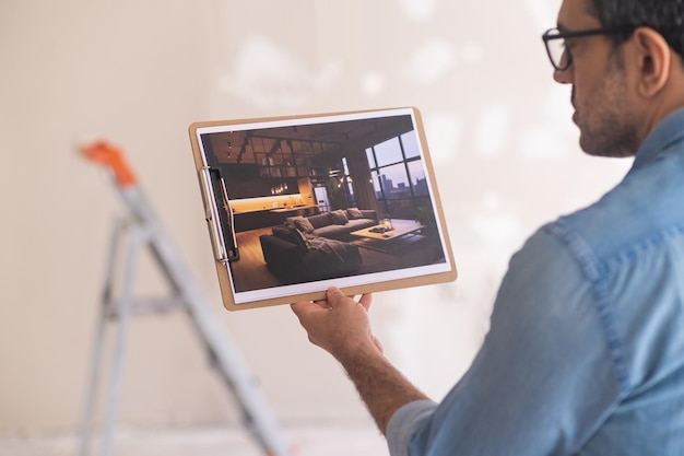 El hombre imaginando una renovación terminada en una casa nueva mira la imagen con diseño de interiores