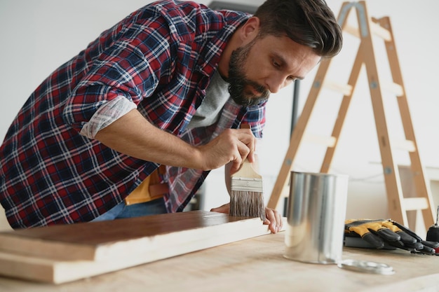 Hombre impregnando una tabla cruda