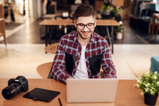 Hombre independiente escribiendo en la computadora portátil sentado en el escritorio.