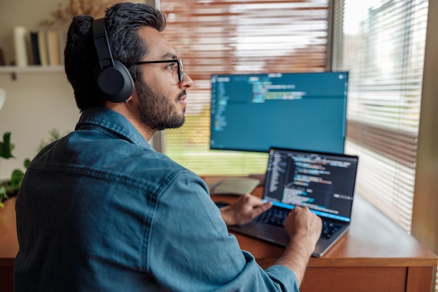 Foto hombre independiente haciendo un nuevo proyecto como diseñador web o programador en su computadora en la oficina de su casa