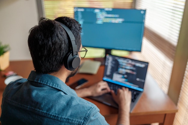 Hombre independiente haciendo un nuevo proyecto como diseñador web o programador en su computadora en la oficina de su casa