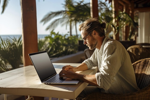 Hombre independiente que usa una computadora portátil en un paisaje tropical Lugar de trabajo remoto en la naturaleza Nómada digital