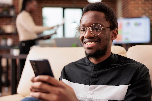 Hombre independiente que usa teléfono móvil para navegar por el sitio web de Internet, creando un informe comercial y una presentación en línea. Trabajando en una aplicación para teléfonos inteligentes para planificar la información de la empresa de datos de investigación.