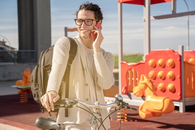 Hombre independiente mediante teléfono móvil en bicicleta