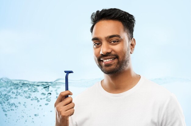 hombre indio afeitando la barba con una hoja de afeitar