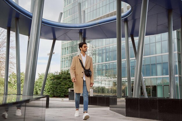 hombre indio caminando por el distrito de negocios vestido con ropa elegante