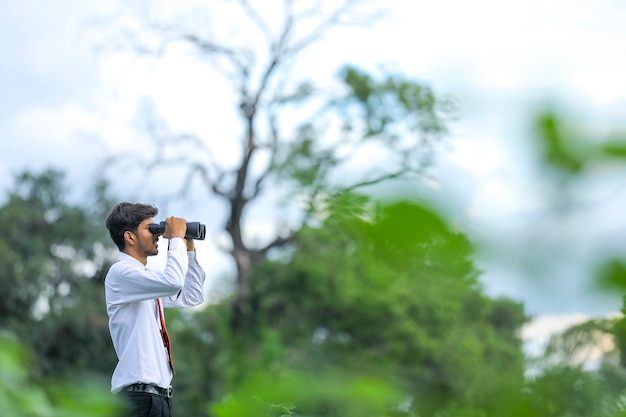 Hombre indio disfruta de la naturaleza con binoculares