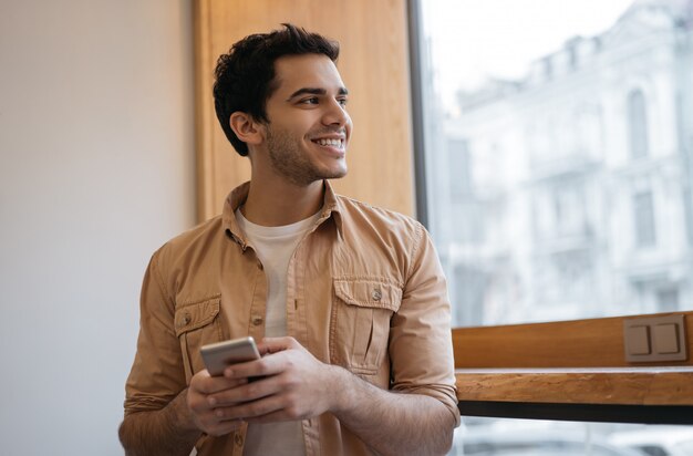 Hombre indio exitoso que usa un teléfono inteligente con aplicación móvil para pedir comida en línea