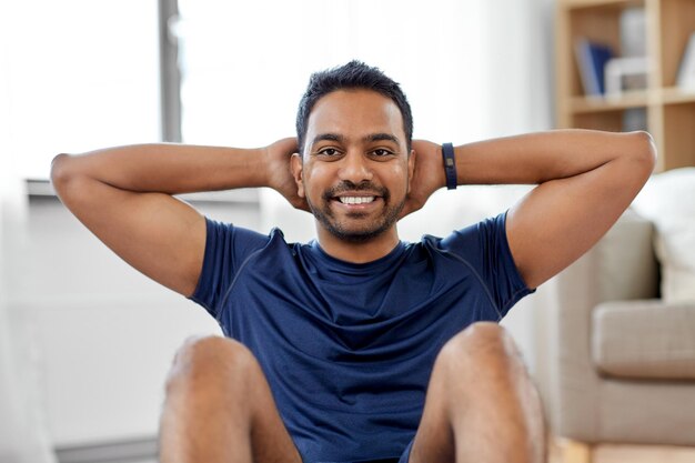 Foto hombre indio haciendo ejercicios abdominales en casa