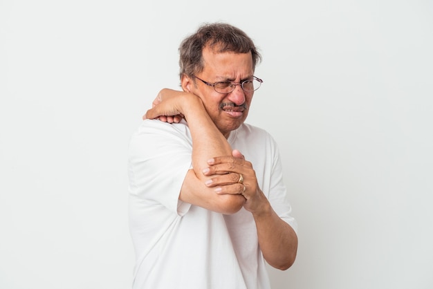 Hombre indio de mediana edad aislado sobre fondo blanco con dolor de cuello debido al estrés, masajeando y tocándolo con la mano.