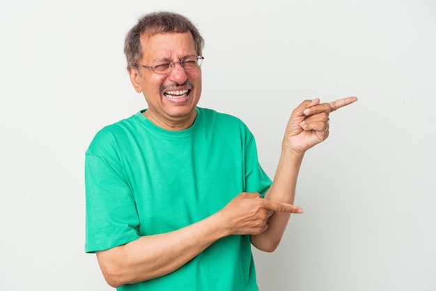 Hombre indio de mediana edad aislado sobre fondo blanco emocionado apuntando con el dedo índice.