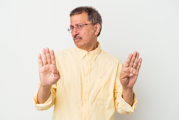 Hombre indio de mediana edad aislado sobre fondo blanco de pie con la mano extendida mostrando la señal de stop, impidiéndote.