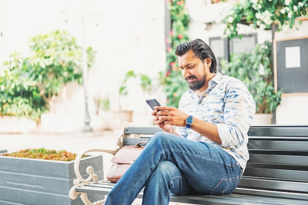 Hombre indio que usa el teléfono móvil al aire libre