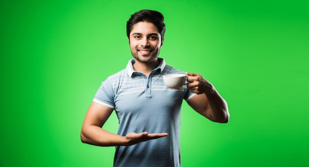 Hombre indio con taza de té o café o taza. Beber, presentar o sostener estando aislado