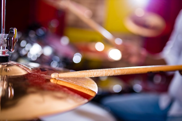 Hombre indio tocando los palos de batería de cerca en el estudio de grabación