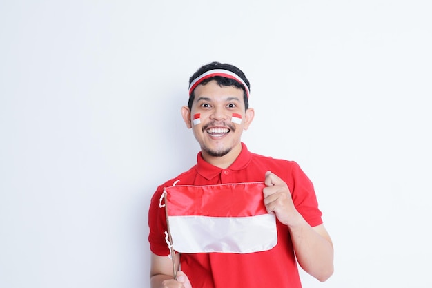 El hombre indonesio apretó el puño con la bandera roja y blanca mostrando emoción