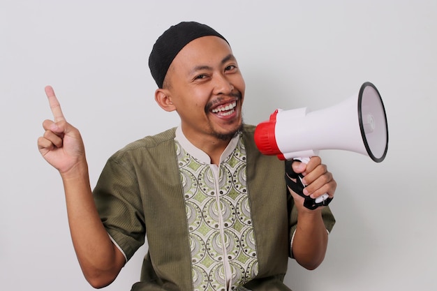Hombre indonesio promueve puntos de venta de Ramadán para copiar espacio mientras sostiene el megáfono