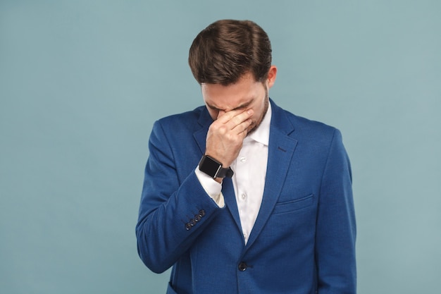 Hombre infeliz llorando con los ojos cerrados y tiene un problema