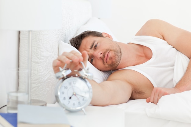 Foto un hombre infeliz en su cama antes de despertarse