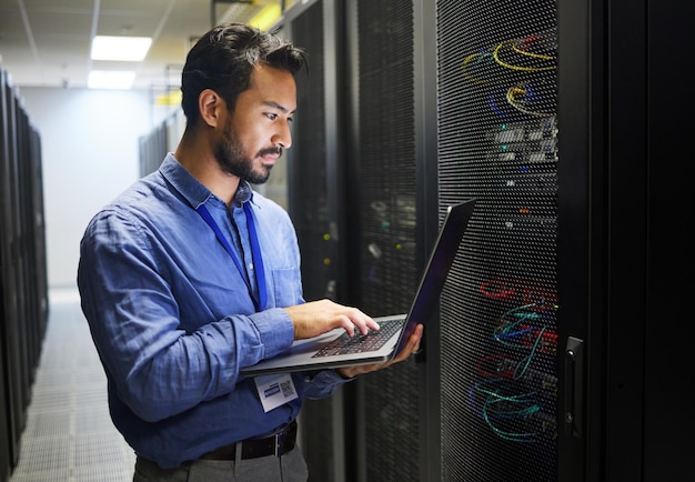 Hombre de ingeniería inspección de sala de servidores de centros de datos y computadoras portátiles o codificación de soluciones de sistemas y persona de TI de redes comerciales en computadora para actualización tecnológica programación gdpr y resolución de problemas de hardware