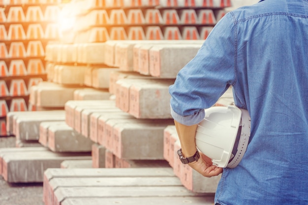 Foto hombre de ingeniería en jean azul con casco blanco en la mano en el sitio de construcción