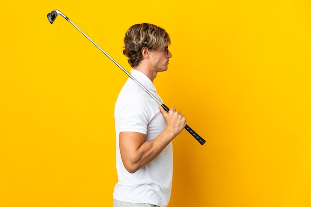 Hombre inglés aislado jugando al golf en posición lateral