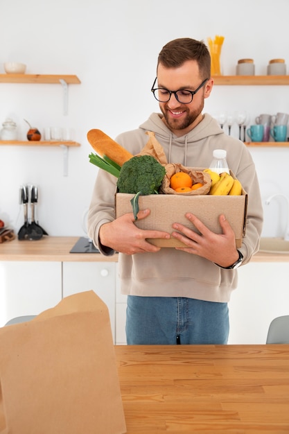 Foto hombre inspeccionando su entrega de comestibles