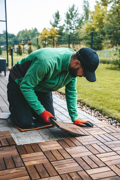 Un hombre instalando tablones de madera construyendo una hermosa terraza en casa