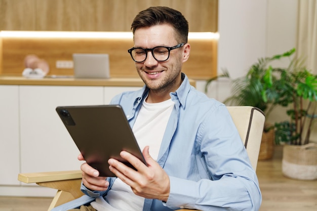 Foto un hombre inteligente con ropa casual disfruta usando una tableta en un ambiente de oficina cómodo con vegetación