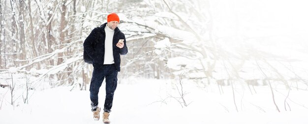 Un hombre en el invierno en el bosque. Un turista con mochila recorre el bosque en invierno. Ascenso invernal.