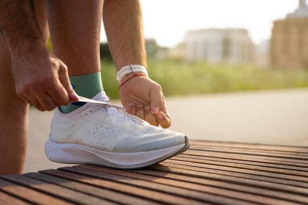 Hombre irreconocible atándose los zapatos