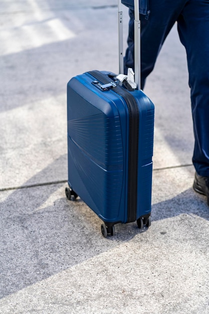 Hombre irreconocible con bolsa y maleta caminando en la terminal de tren