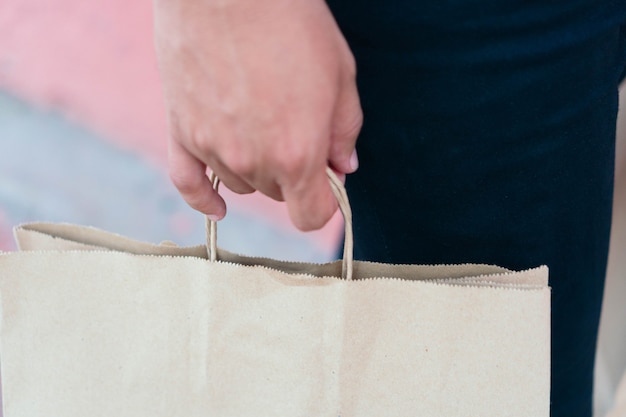 Hombre irreconocible con bolsas de compras, caminando en la calle