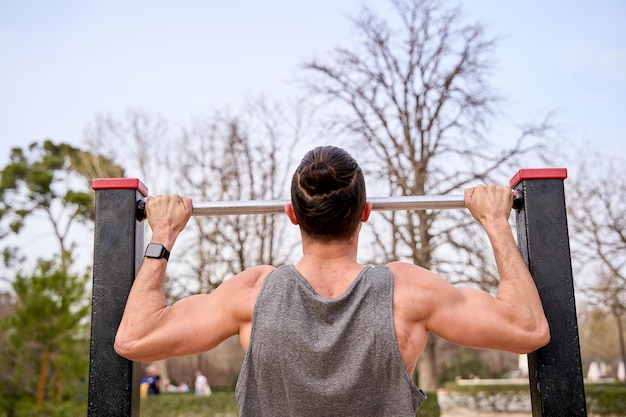 Foto hombre irreconocible entrenando en un parque de calistenia